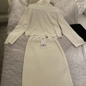 Stickat set säljes - Set i kjol och polotröja till salu.  Aldrig använd, med etikett.