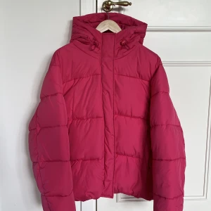 Rosa vinterjacka  - Rosa vinterjacka i en kortare modell från lager 157, storlek M. Jackan är använd sparsamt och är därför i väldigt gott skick.