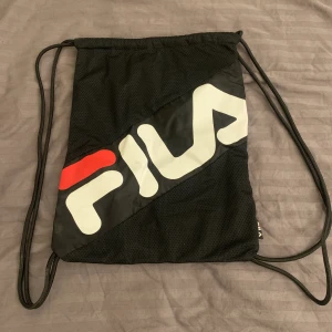 Fila väska - Svart klassisk gympapåse från Fila. Den har dubbla tyglager vilket ger en lyxigare känsla. I princip oanvänd. 