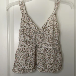 En blommig volangtopp i storlek XS/S❤️👚 - En riktigt vacker sommar topp med blommigt mönster. Toppen är lite v ringad men det går att fixa med säkerhetsnål. Jag säljer denna underbara topp eftersom den sorgligt nog aldrig används!❤️