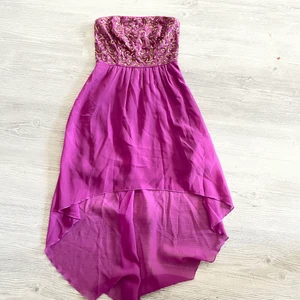 Bodyflirt klänning - Fin lila klänning i storlek 34. Guldiga paljettdetaljer på framsidan. Behövs strykas. Finns en jätteliten fläck på baksidan av klänningen men det är inget som syns. Kan skickas då köpare står för frakt.