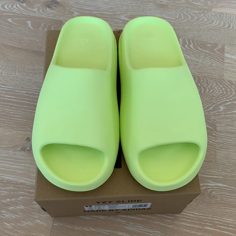 Yeezy Slide ”Glow Green” Säljer då dom var för små skulle tagit en storlek över din vanliga. helt orörda 10/10. Skor.