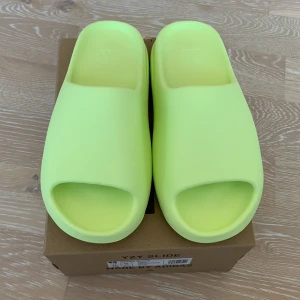 Yeezy Slide ”Glow Green” strl 44,5 - Yeezy Slide ”Glow Green” Säljer då dom var för små skulle tagit en storlek över din vanliga. helt orörda 10/10