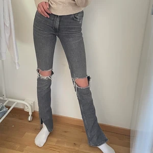 Gråa Zara jeans med hål  - Säljer dessa gråa jeansen i stl 32 från zara med hål på knäna samt med slits. Säljer för att de inte kommer till användning💓💓(är 170cm)  190kr+66kr frakt