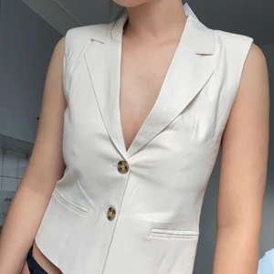 väst beige - ljusbeige väst med bruna melerade knappar. aldrig använd med lappen kvar!