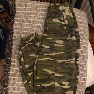 Camouflage byxor - Säljer ett par camouflage byxor från Gina tricot. Byxorna saknar snöre vid midjan men dom har en ganska bred resår. Byxor sitter baggy.