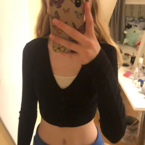 Långärmad ”kofta” - En långärmad ”kofta” i ribbat material, den är i bra skick. Den är ganska kort