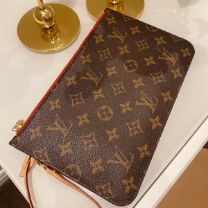 Louis Vuitton Neverfull Pochette - Nu är det dags för mig att säga farväl till min finaste ägodel! Min fina Neverfull Pochette som är i TOPPSKICK!  Den köptes 2019 och har tagits väl hand om. Inget att anmärka på! Jag skickar förstås digitalt kvitto vid intresse. Hör av er för fler bilder!