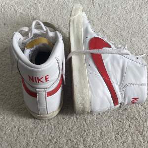 Nikeskor modell NSW Nike Blazer mid ’77. Färg vit/röd. Köpta för ca 1,5 år sedan. Använda 5-10 ggr. Fint skick, det som är ”smutsigt” syns på bilderna. Strl US, 8.5 EUR 40. Jag köpte dem för från Nelly de nypris är 1 149 kr. Fler bilder kan skickas. 