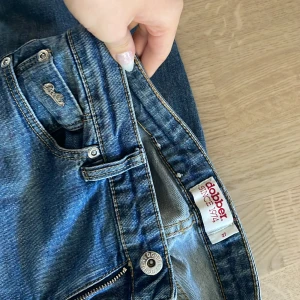 Dobber jeans - Så fina o snygga midwaist/lowwaist  dobberjeansmed fragtkedjor vid anklarna. Märkes jeans i bra skick. 