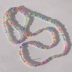 Halsband gjort med glas och plast pärlor med stretchig tråd.