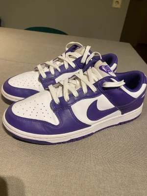 Nike Dunk Court Purple - Bra skick - Storlek 43. Mycket bra skick. Bara använda 15-20 gånger. Köpta för mindre än ett år sen från Stock X dock så har lådan och taggen försvunnit. Trycket på sulan har gått loss också. Frakt tillkommer. Skicka dm. Kan gå lägre vid snabb affär.