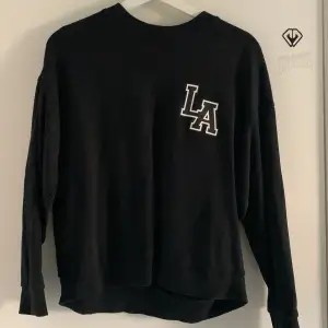 Enkel svart tröja med tryck (LA) i vitt. Är ifrån Gina tricot i storlek S passar också en Xs. 