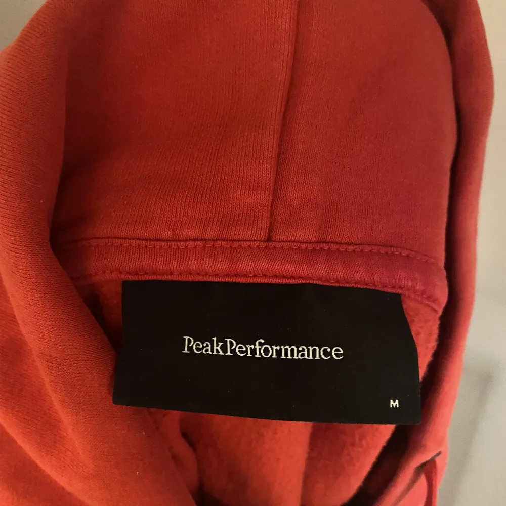 Röd hoodie från Peak Performance. Knappt använd. Storlek M. Hoodies.
