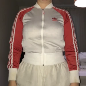 Adidasjacka - Adidasjacka i rött, vitt och lite grå vit. Väl använd och lite nopprig samt att insidan av kragen i nacken och ärmarna har gulnat, men det syns inte supermycket när man har på sig den. 