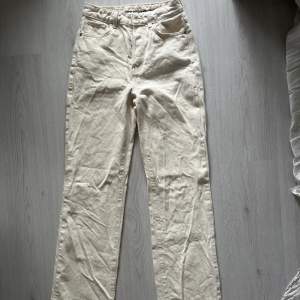 Beige / vita utsvängda jeans från Bikbok i storlek 26. Knappt använda