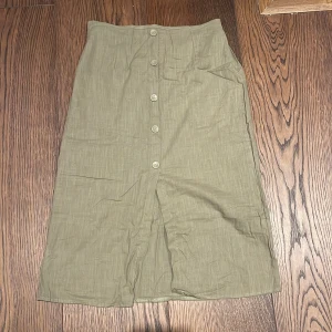 Grön kjol - Olivgrön linne kjol med slits där fram, mellan längd. Storlek M, 100kr+frakt 