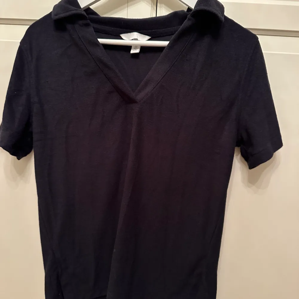 En marinblå frotté t-shirt med en typ av krage. Använd få gånger, storlek s, skön passform.. T-shirts.