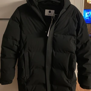 NN07 Jacka  - - NN07  - Svart  - Lite längre än vanlig midje jacka  - Varm och bekväm.  - Storlek S  - Nyskick, använd fåtal gånger.  - Nypris (köpt för): 5999kr  - Prislapp sitter kvar på jackan.   MER ÄN HALVA PRISET  