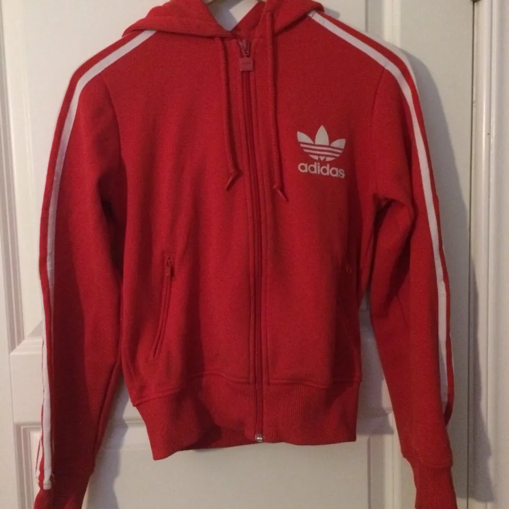 Jag säljer min röda adidas hoodie då den inte har kommit till användning. Jag köpte den på sellpy men är i bra kvalitet och jag hittar inga defekter💕den är ganska lite i storleken så skulle själv säga att den passar XS eller S.. Hoodies.