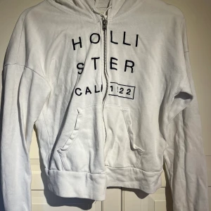 Vit hollister zip-hoodie - Vit hollister zip-hoodie i storlek S. Har ett litet hål vid armen men inget som syns. Pris: 90kr + frakt 