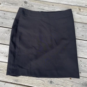 Svart Kjol, 40, H&M - Svart kostymkjol i polyester. Fin och proffsig, men en aning för stor för mig så den kommer inte till användning. Hel och inga fläckar. Kan mötas upp i ÖSD. 