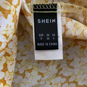 Gul blommig klänning från Shein i storlek S/36. Rosettknytning på sidan och stretch vid ryggen. Endast provad. Köparen står för frakt🌻