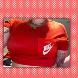 Röd Nike t-shirt - Röd t shirt från märket ”Nike”. Knappt använd. Är i mycket gott skick! Storlek: M❤️❤️❤️ (ser ut som en magtröja på bilden men är igentligen bara en vanlig t-shirt som jag vikt upp 😅😅)