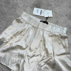Zara satinshorts  - Shorts i beige satin från zara, oanvända!