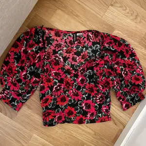 En blommig t-shirt med puffärmar från H&M (DIVIDED) Storlek: S 