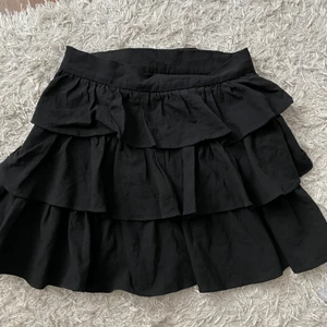 Svart kjol - Fin kjol med volanger. Inte så stretchigt material men finns dragkedja så den sitter jättebra. Säljer då den inte kommer till användning 🖤