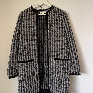Kappa/rock - Säljer denna kappan/rocken från h&m. Knappt använd. Den är svart med vit/guld/silver detaljer.