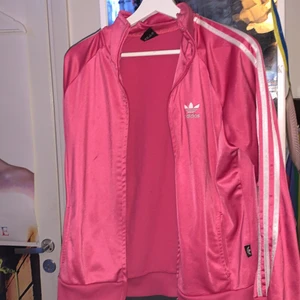 rosa adidas kofta  - jättefin rosa adidas kofta från sellpy som ja älskar men det är tyvärr inte min färg. den är använd 1 gång och är i fint skick förutom några små fläckar på framsidan (sista bild) men dom syns inte. storleken säger xxl men den är inte alls så stor, skulle säga den är Medium. sitter inte oversized. 
