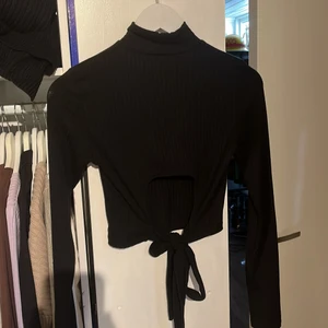 Tröja med öppen rygg - Svart ribbad tröja men knyte från nakd. Använd 3 gånger så i nyskick. Storlek Xs