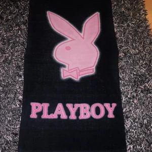 STOR PLAYBOY HANDDUK - En riktigt fin och stor playboy handduk. Den har svart/grön aktig färg och rosa tecken med vita kanter. 
