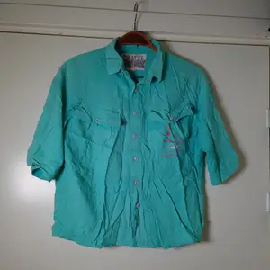 Kortärmad vintageskjorta med tryck på bröstfickan. Behöver strykas 🙈