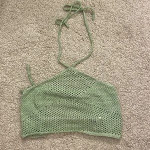 Topp  - Liten grön stickad topp från SHEIN med knytdetaljer runt hals och på ryggen. Säljer tillhörande kjol. Är en bikini coverup men måste ej användas till det.