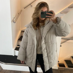 Vinterjacka  - Gosig och stor vinterjacka från Monki. 100% polyester och väldigt varm. Stor luva. Inga anmärkningar. Storlek S men oversized. Färgen är ljus ljus grå. 