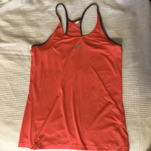 Träningslinne från Adidas - Säljer detta träningslinne från Adidas då det aldrig kommit till användning. Lite tajtare passform i väldigt skönt material