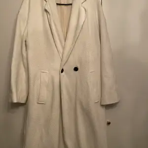 En vit lång kappa i storlek s från Zara