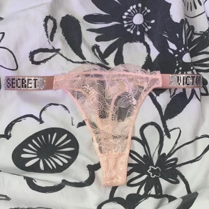 Victoria’s Secret trosor strass babyrosa - Jättefina och sexiga Victoria’s Secret spets trosor som är helt nya därmed oanvända. Är i färgen babyrosa/ljusrosa. Storleken är M men passar även de som har S. Har strass vid sidorna. Köparen står för frakten ❤️