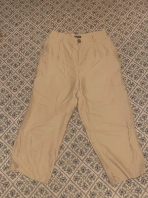 Tygbyxor - Beiga tygbyxor från lindex. Brett midjeparti och lätt utsvängning
