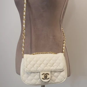 Vit axelremsväska med guldkedja axelrem - Mått 19×13×4cm Fuskskinn "kopia" Guldfärgad metall/detaljer  Skickas spårbart.  Mvh