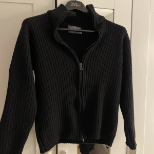 Stickad Zip tröja - Säljer min svarta stickade Zip tröja. Den är tjock i materialet och knappt använd. Den är även liten i storleken. Köparen står för frakten.