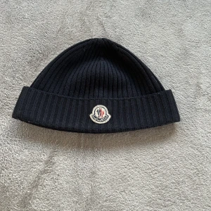 INTEESSEKOLL MONCLER MÖSSA - Hej lägger ut denna välskötta Moncler mösssa för intressekoll. Mössan är självklart äkta då det finns QR kor som visas (kolla bilderna) skriv privat för vad du kan ge för den. Färgen är mörkblå.