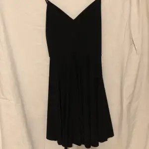 Svart fin klänning med flowy kjol korsande band på ryggen och v ringning (använd en gång)