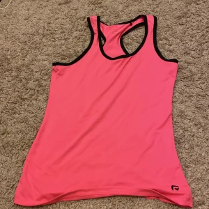 Ett rosa tränings linne - Det är ett rosa tränings linne med svarta dittaljer