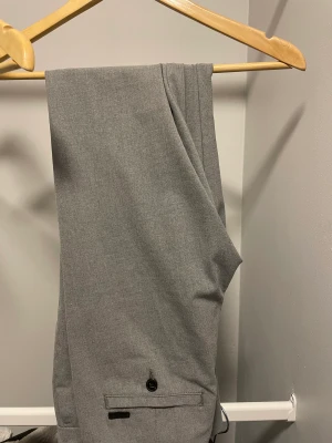 Gråa kostymbyxor  - Dem här byxorna är använda ett fåtal gånger men ser ut att vara i nyskick. Sitter perfekt i längden på mig som är 184cm men lite liten, sitter lite för tajt.  Byxorna har storlek 30/34 i sig. 