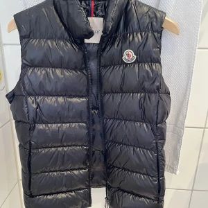 Moncler väst dam  - Hej! Säljer nu min fina och knappt använda Chany Down Gilet väst från moncler. Köpt på monclers hemsida, kvitto finns. Västen är som sagt som ny, använd ett fåtal gånger bara. Är i storlek 3 vilket motsvarar en M. Kan även passa en S. 