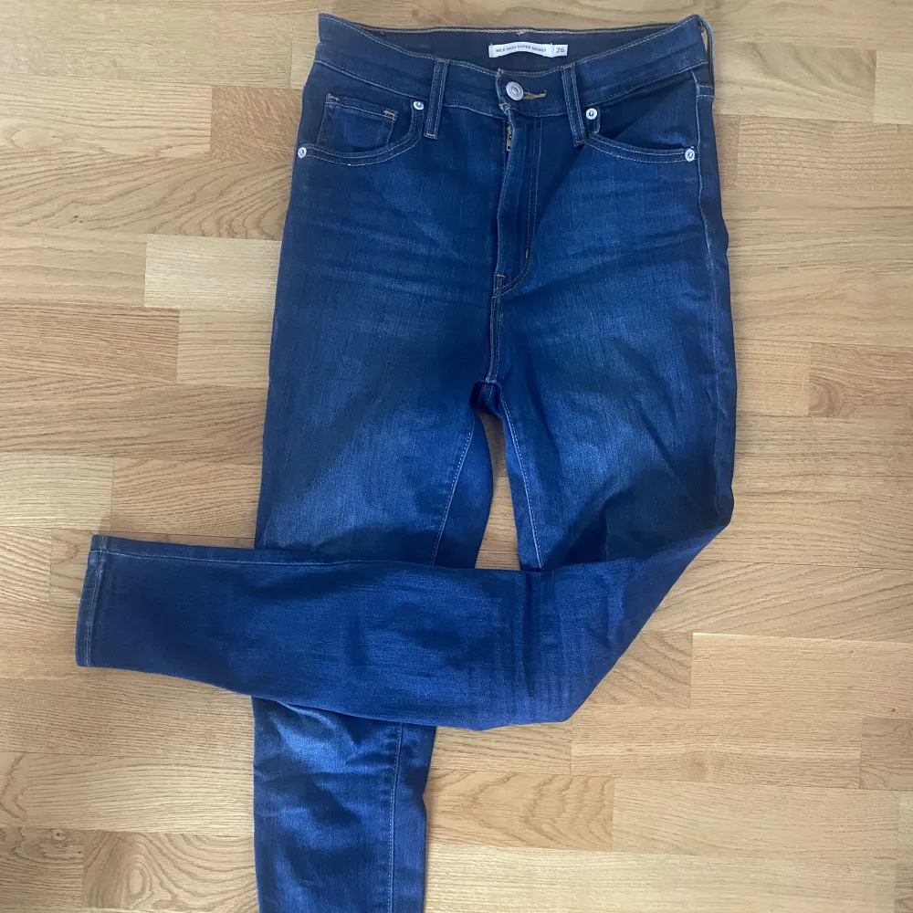 Mörkblå jeans ifrån Levi’s i modell Mile High Super Skinny. Knappt använda så i superfint skick. Storlek 26, jag är en 36a och passar på mig. . Jeans & Byxor.